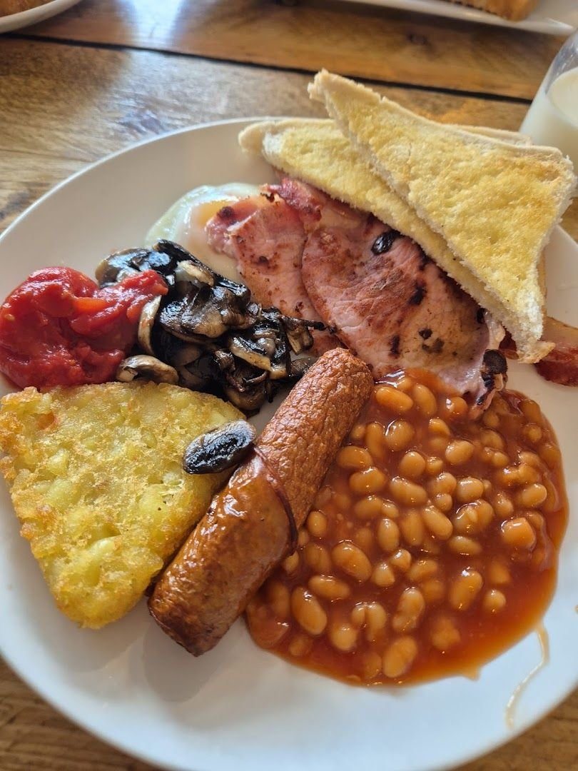 A full English breakfast: bacon, sausage, mushrooms, tomato, a hash brown, beans and fried bread